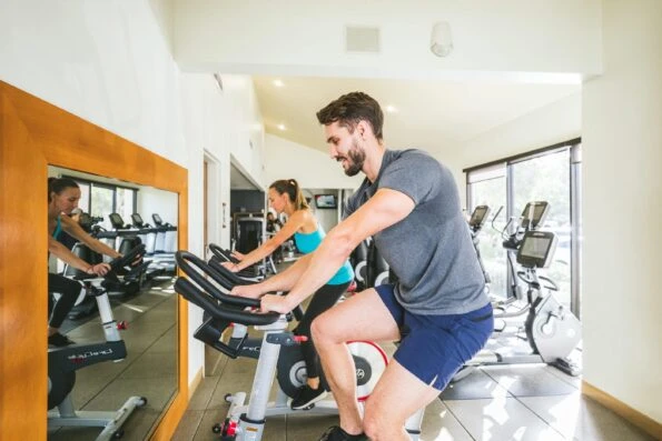A couple works out on exercise bikes in San Diego Mission Bay Resort fitness center.