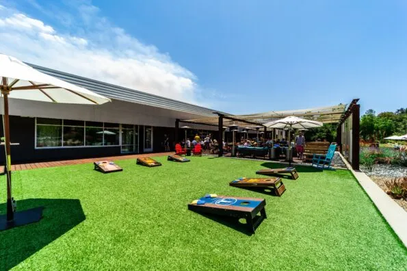 Three sets of corn hole on the outdoor lawn at Farmer & The Seahorse.