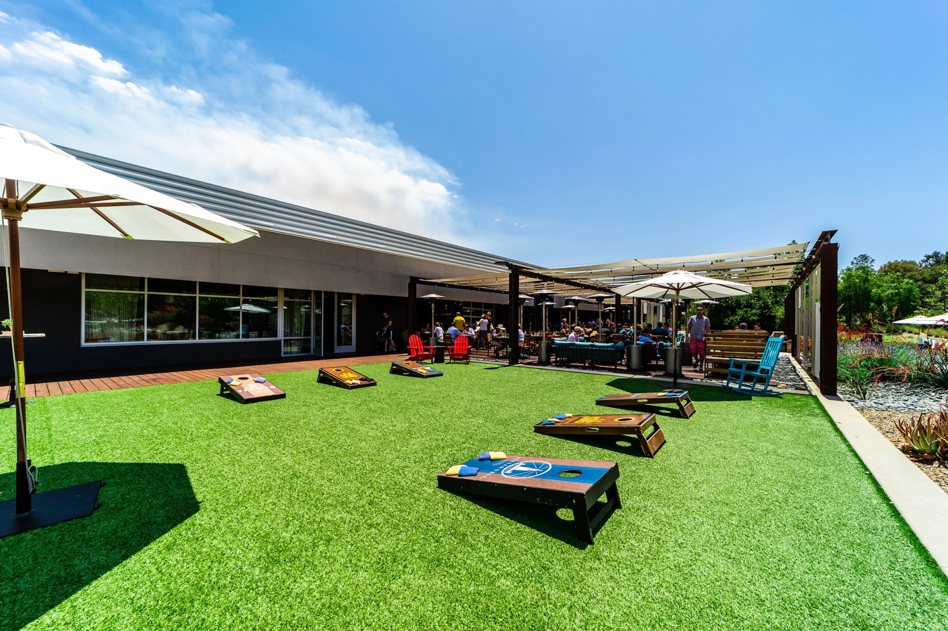 Three sets of corn hole on the outdoor lawn at Farmer & The Seahorse.