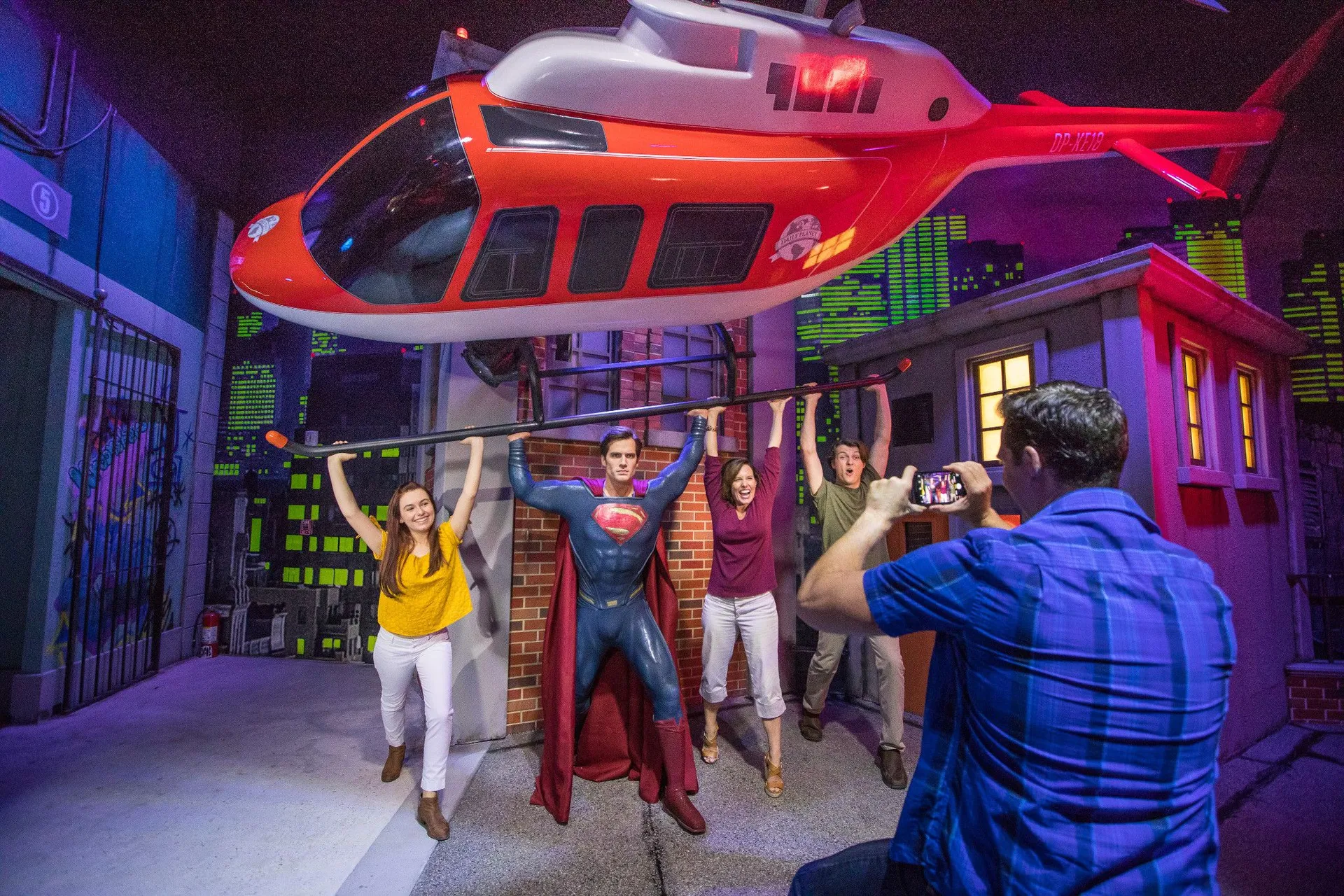 A family poses with a wax Superman at Madame Tussauds Orlando.