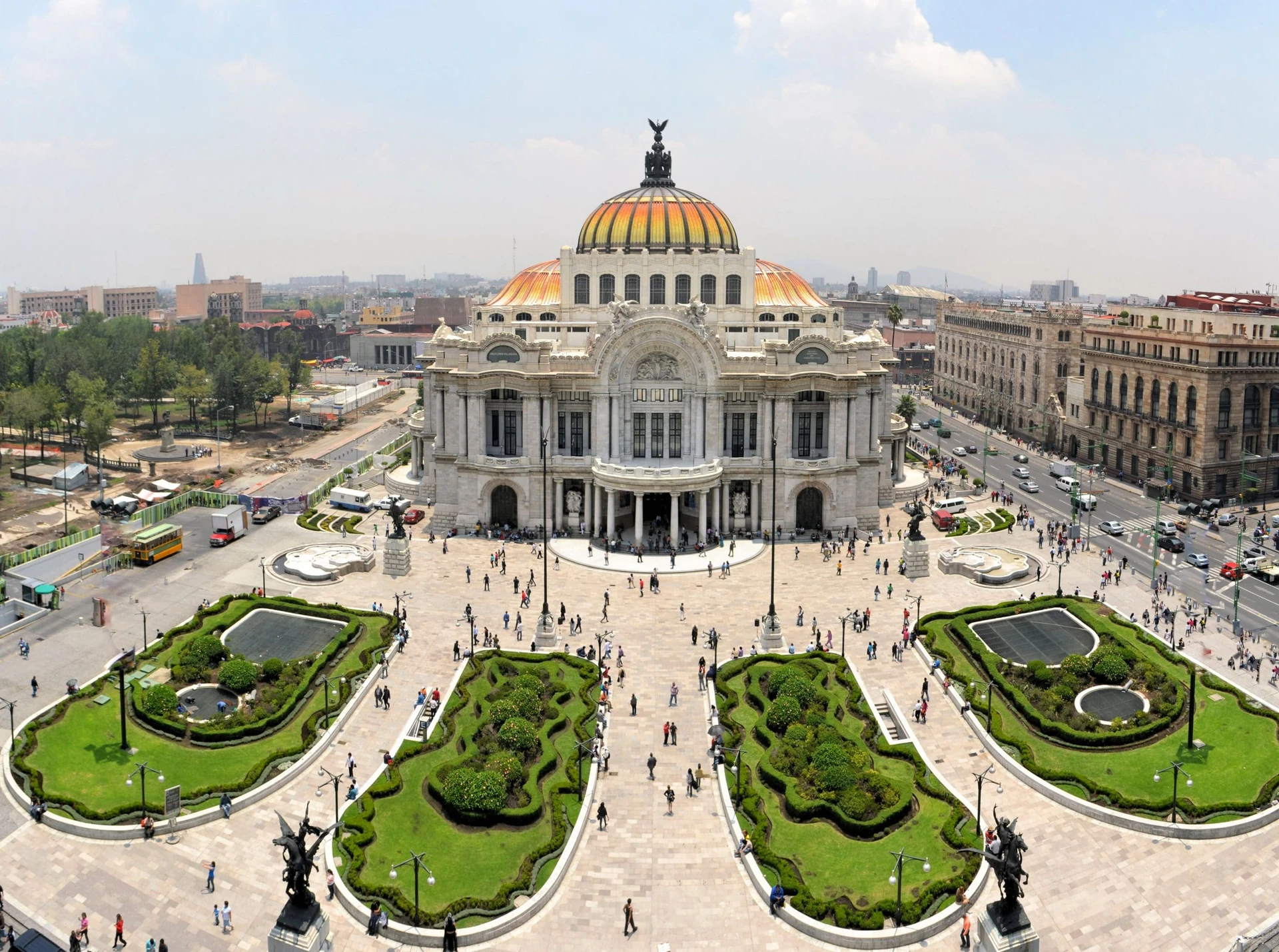 Aerial view of the Palacio de Bellas Artes in Mexico City with people walking around its exterior.