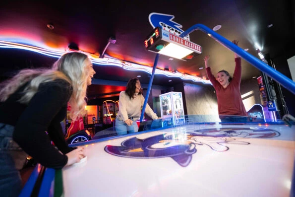 Guests play air hockey in the arcade.