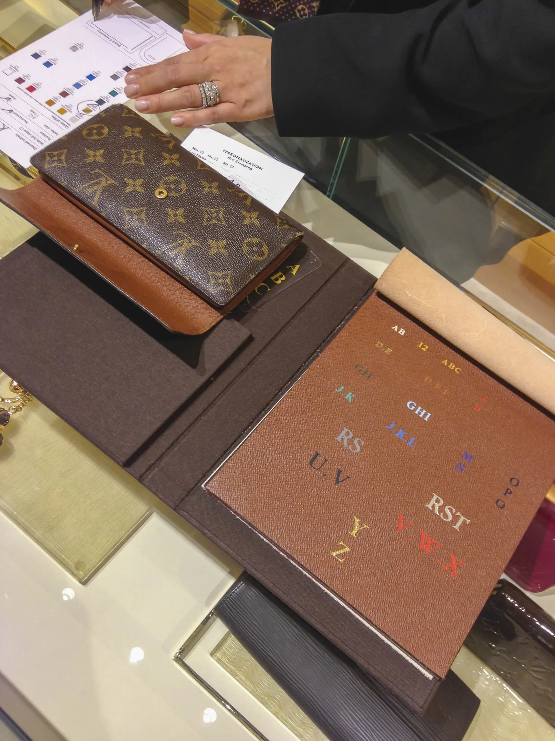 A Louis Vuitton store associate lays out hot stamping colors and styles for my wallet.