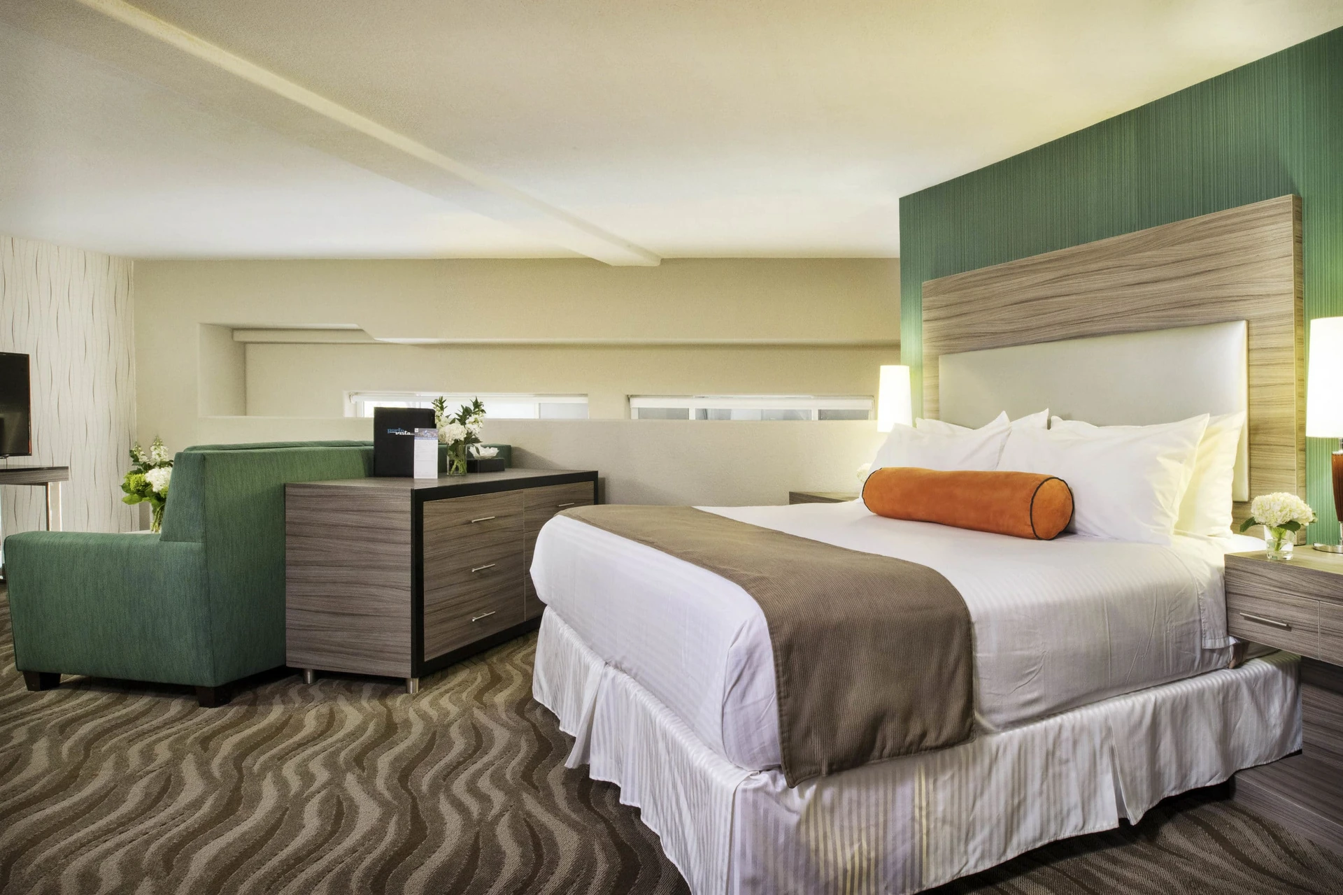 A room interior with neutral colors accented by green and orange at Porto Vista Hotel near San Diego Zoo.