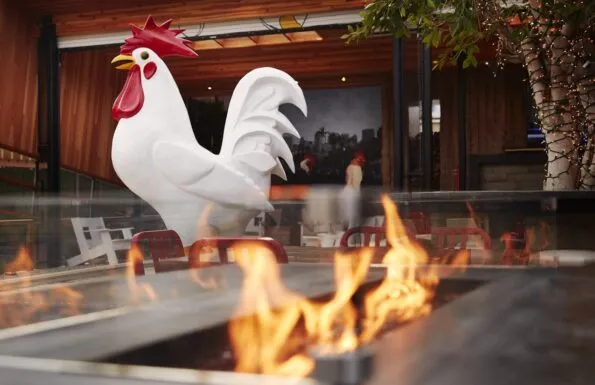 The giant chicken stands tall amid the outdoor seating at Crack Shack, a family-friendly restaurant in Little Italy San Diego.