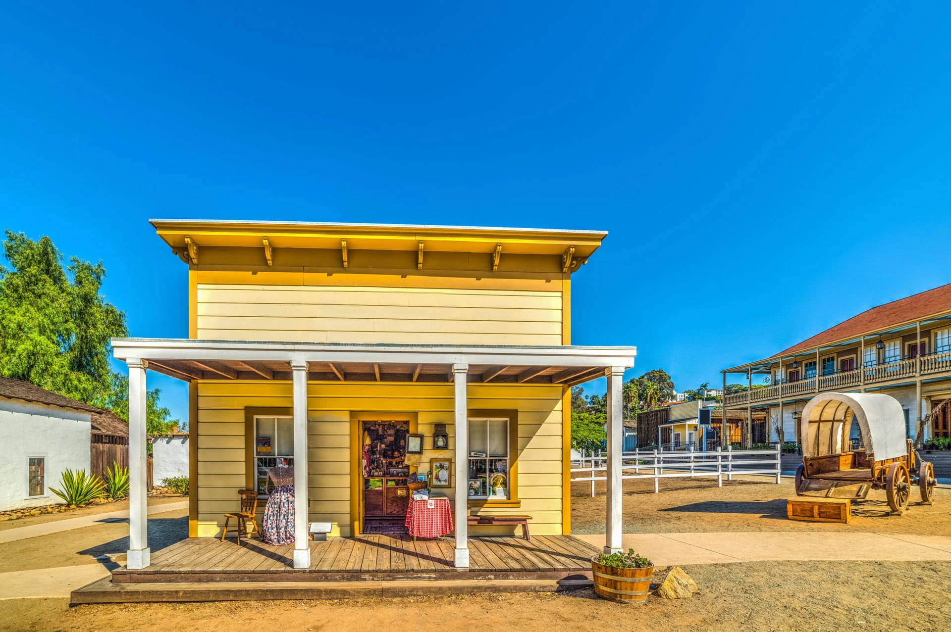 An old wagon next to a small shop that look like a scene from old California in Old Town San Diego.