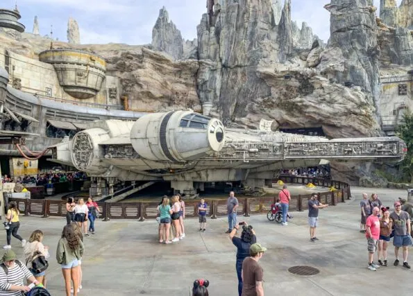 Guests take photos in front of the Millennium Falcon inside of Disneyland's Star Wars: A Galaxy's Edge.