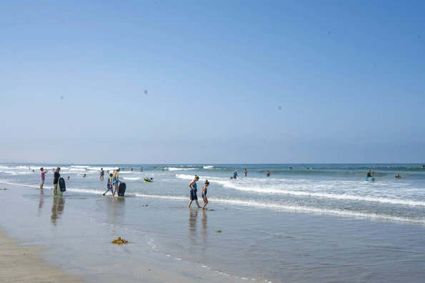 Families boogie boarding and playing at the water's edge at Silver Strand State Beach, a popular Coronado beach.