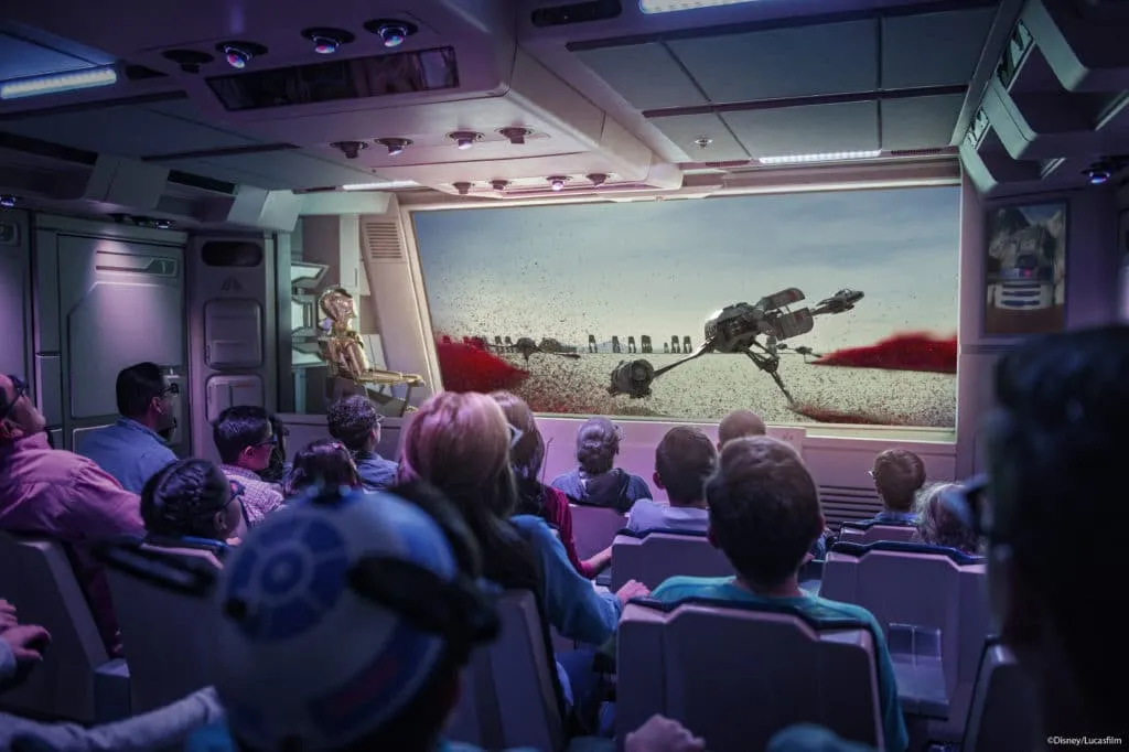 Guests watch the screen on the interior of the Star Tours Disneyland ride.