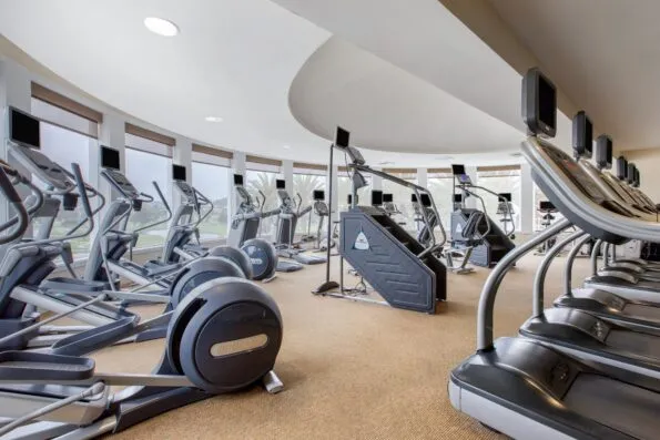 Cardio equipment inside the Athletic Club with views over the golf course.