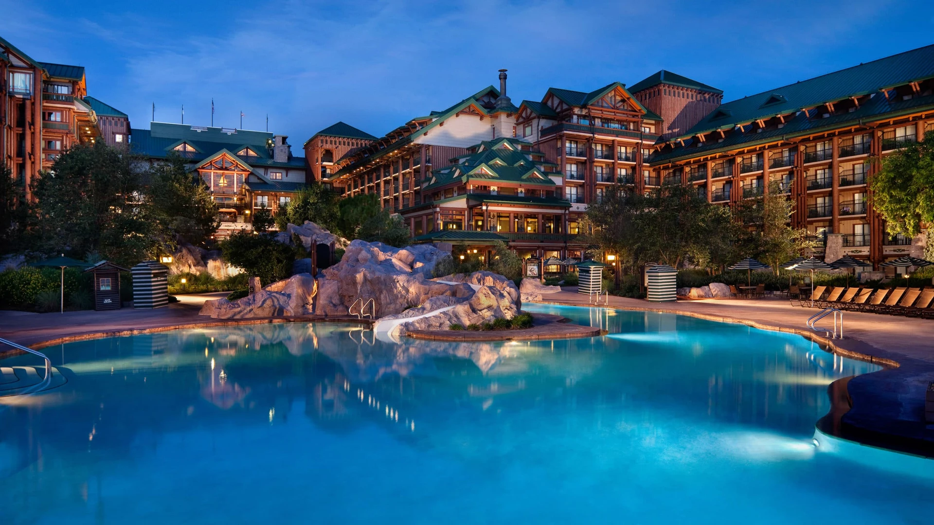 Night view of Disney's Wilderness Lodge Copper Creek Springs pool with water slide for families in Orlando.