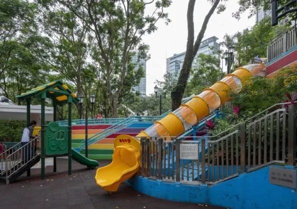 A large tunnel slide and part of the colorful play structure at the Hong Kong Park playground.