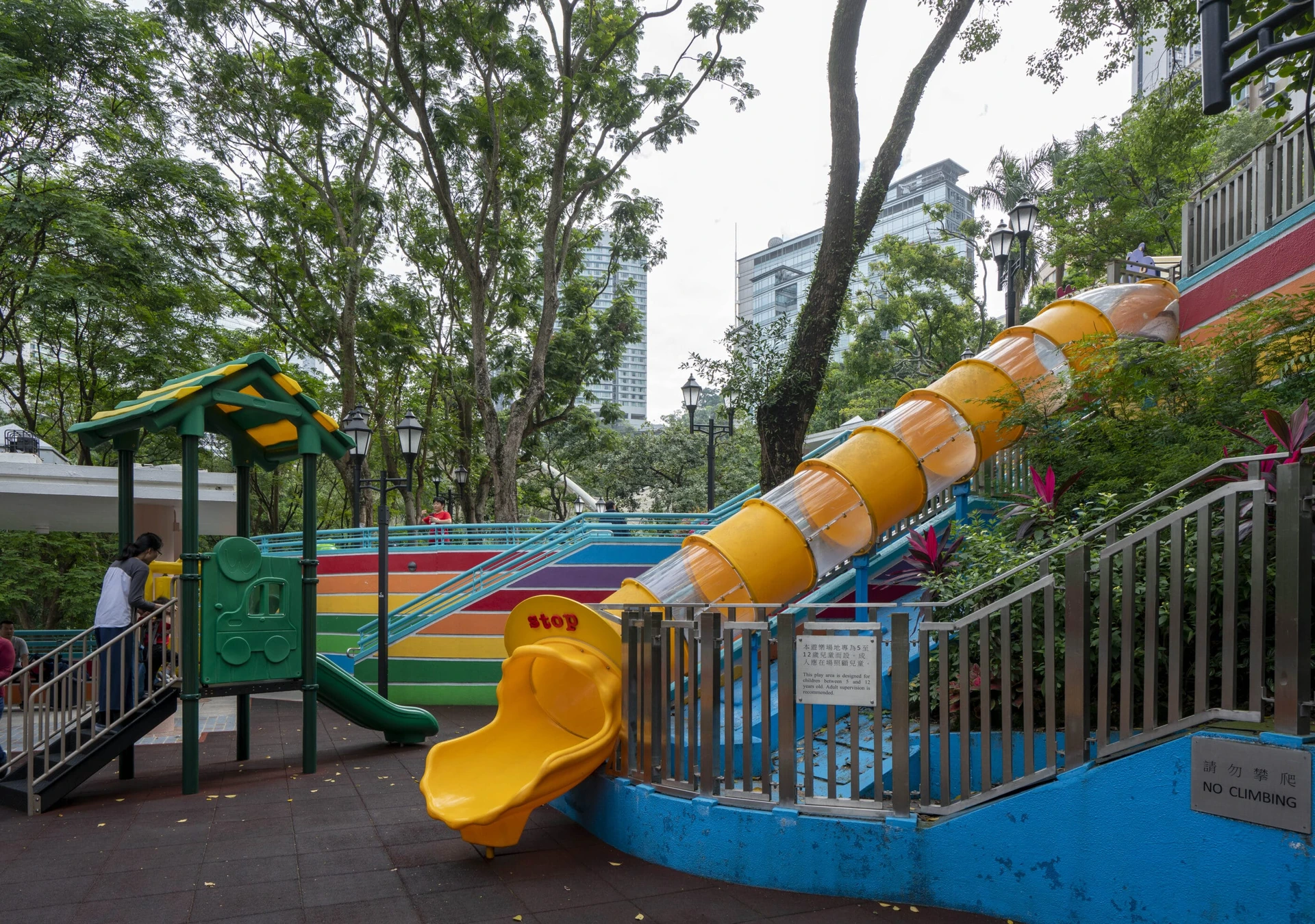 A large tunnel slide and part of the colorful play structure at the Hong Kong Park playground.