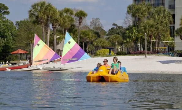 A family pedals a yellow pedal boat on the lake at Hyatt Regency Grand Cyprus.