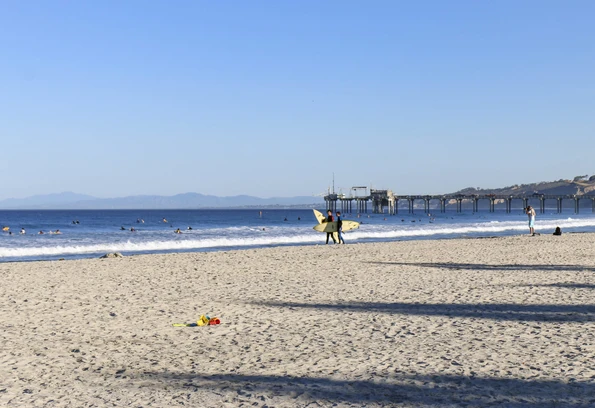 Two surfers walk on the sand on an October morning at La Jolla Shores Beach.