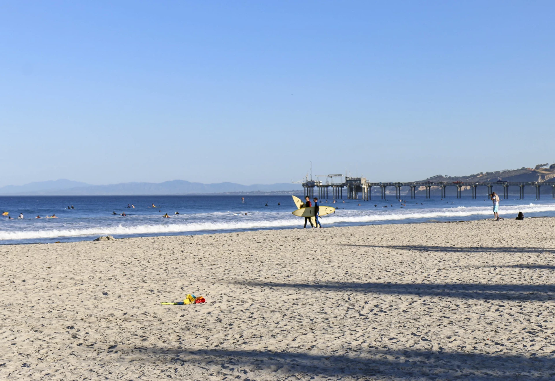 Two surfers walk on the sand on an October morning at La Jolla Shores Beach.
