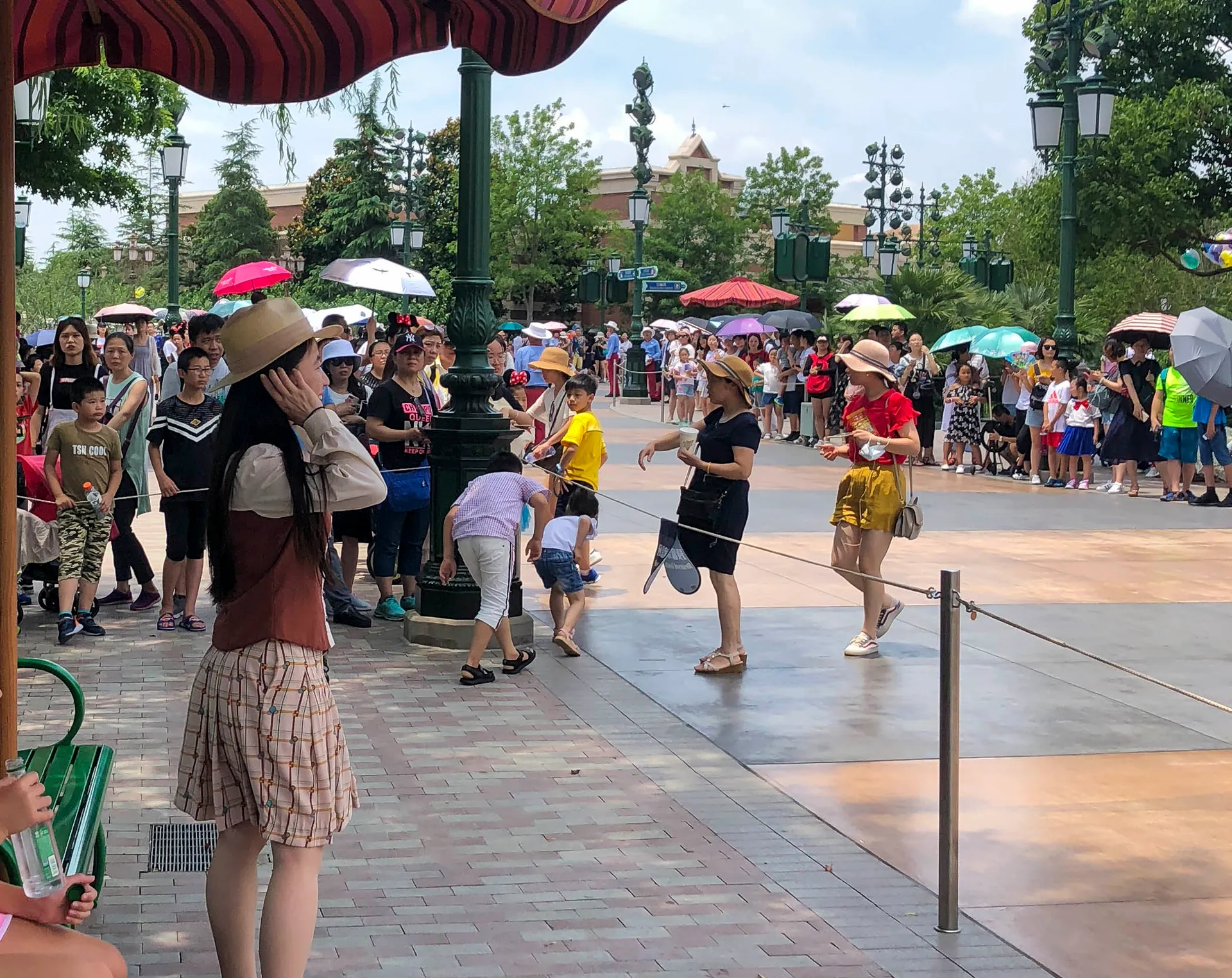 A guide stands in a near-empty reserved parade section for VIP tour guests at Shanghai Disneyland.
