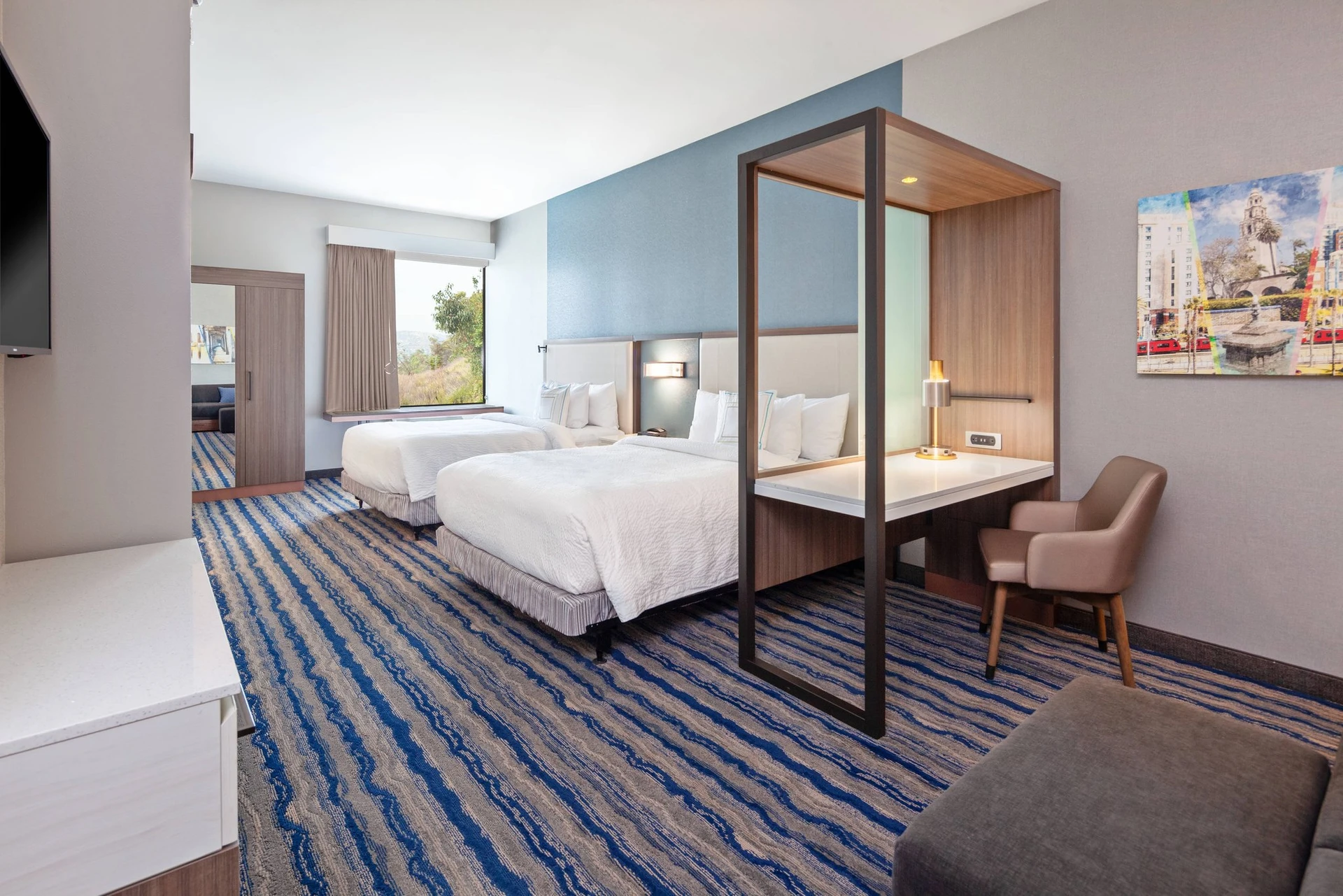 A contemporary double bed room with seating area and desk at Springhill Suites Escondido near San Diego Safari Park.