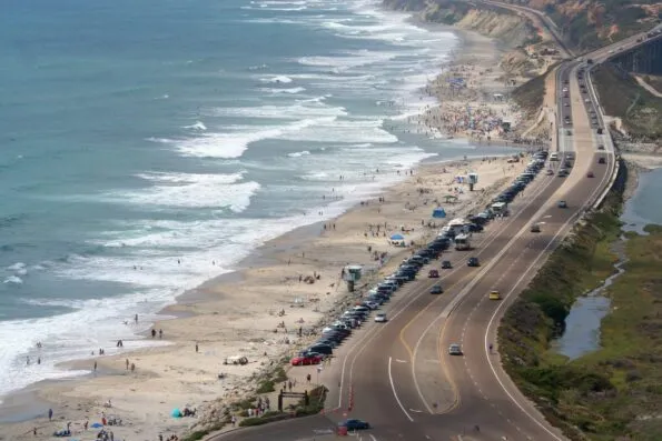 View of crowds enjoying Torrey Pines State Beach, a popular Del Mar Beach.