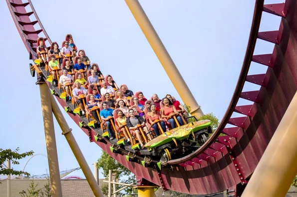 A roller coaster filled with riders on the track at Kings Island theme park.