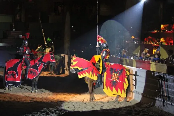 Knights on horses face each other in the arena as diners watch at Medieval Times.