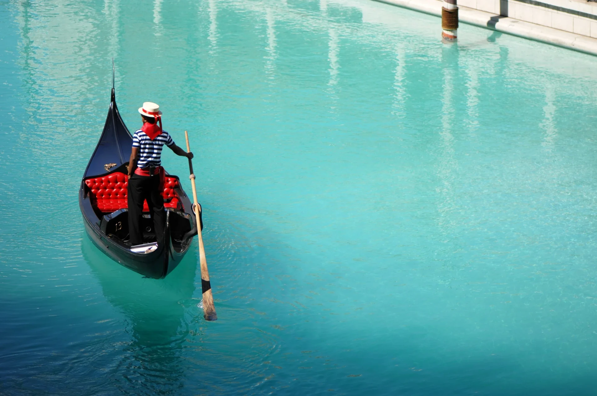 A gondolier paddles a gondola through a canal inside The Venetian hotel.