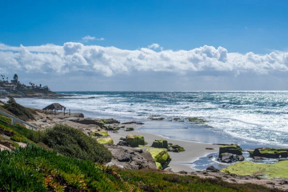 Rocky shoreline with famous shack in the background at Windansea Beach.