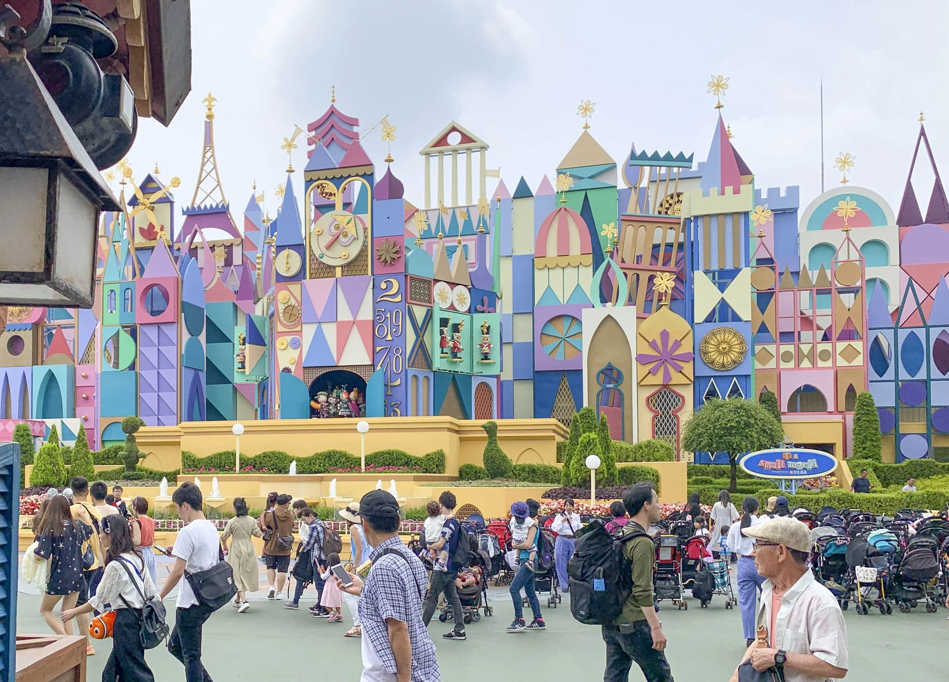 Guests walk around Tokyo Disneyland in front of 