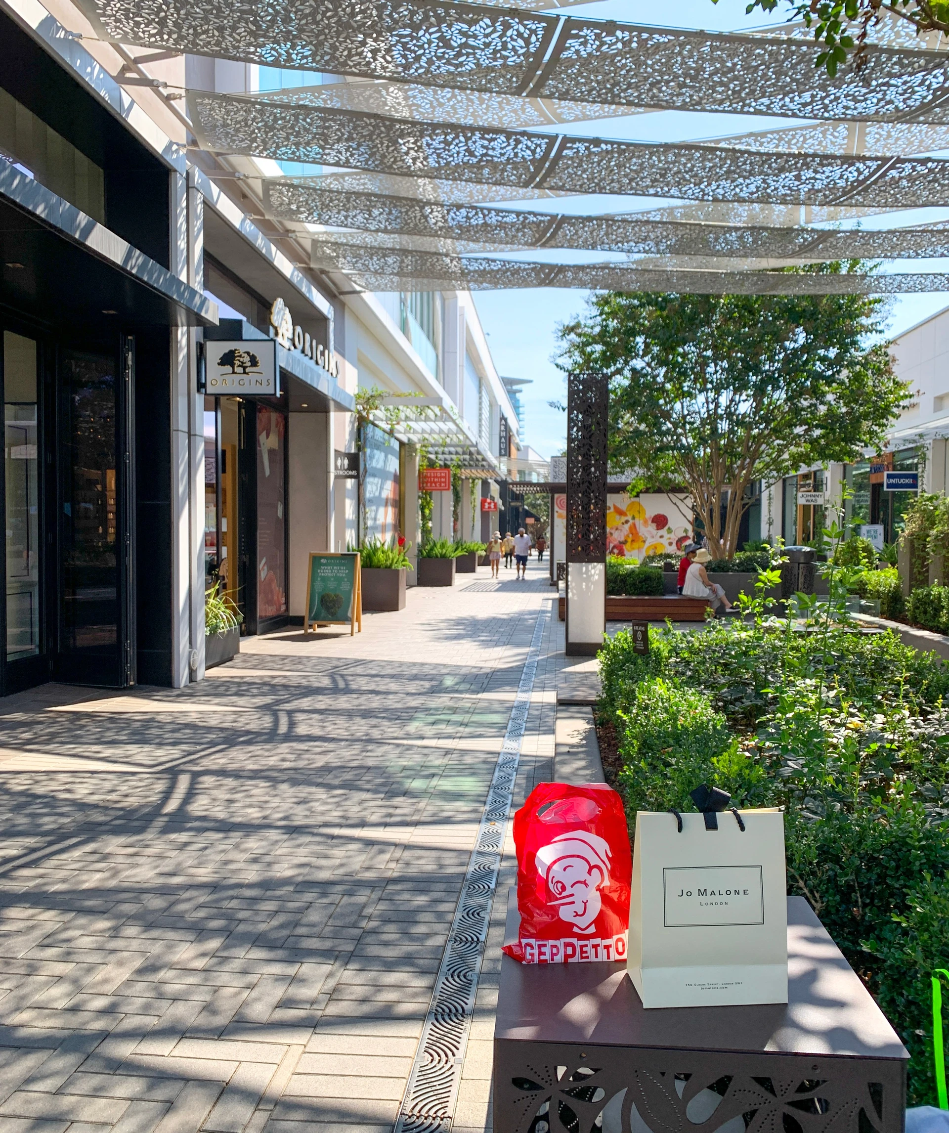 Shopping bags on a bench near Origins at Westfield UTC mall.