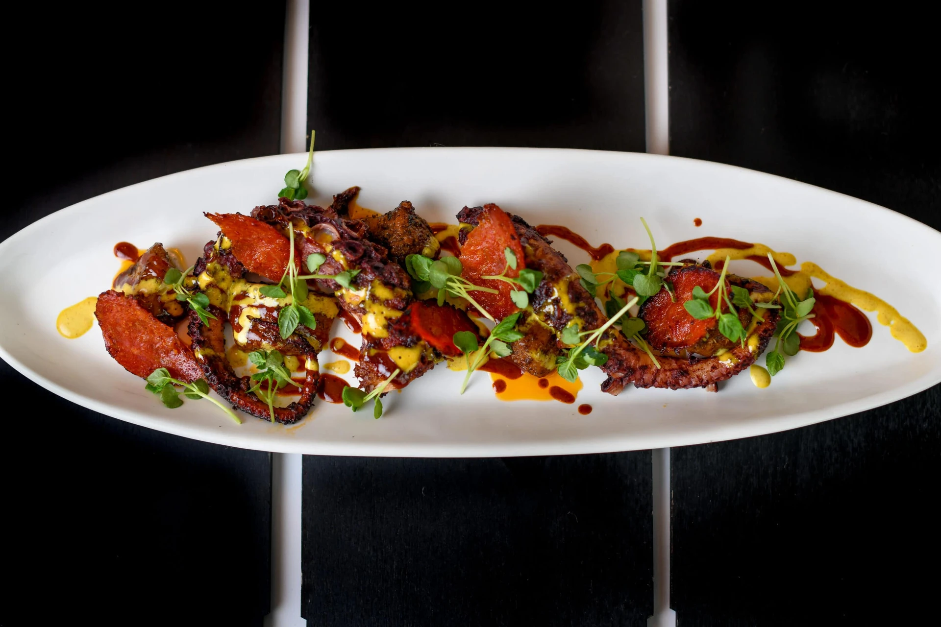 A Grilled Octopus dish on a white plate a The Guild Hotel