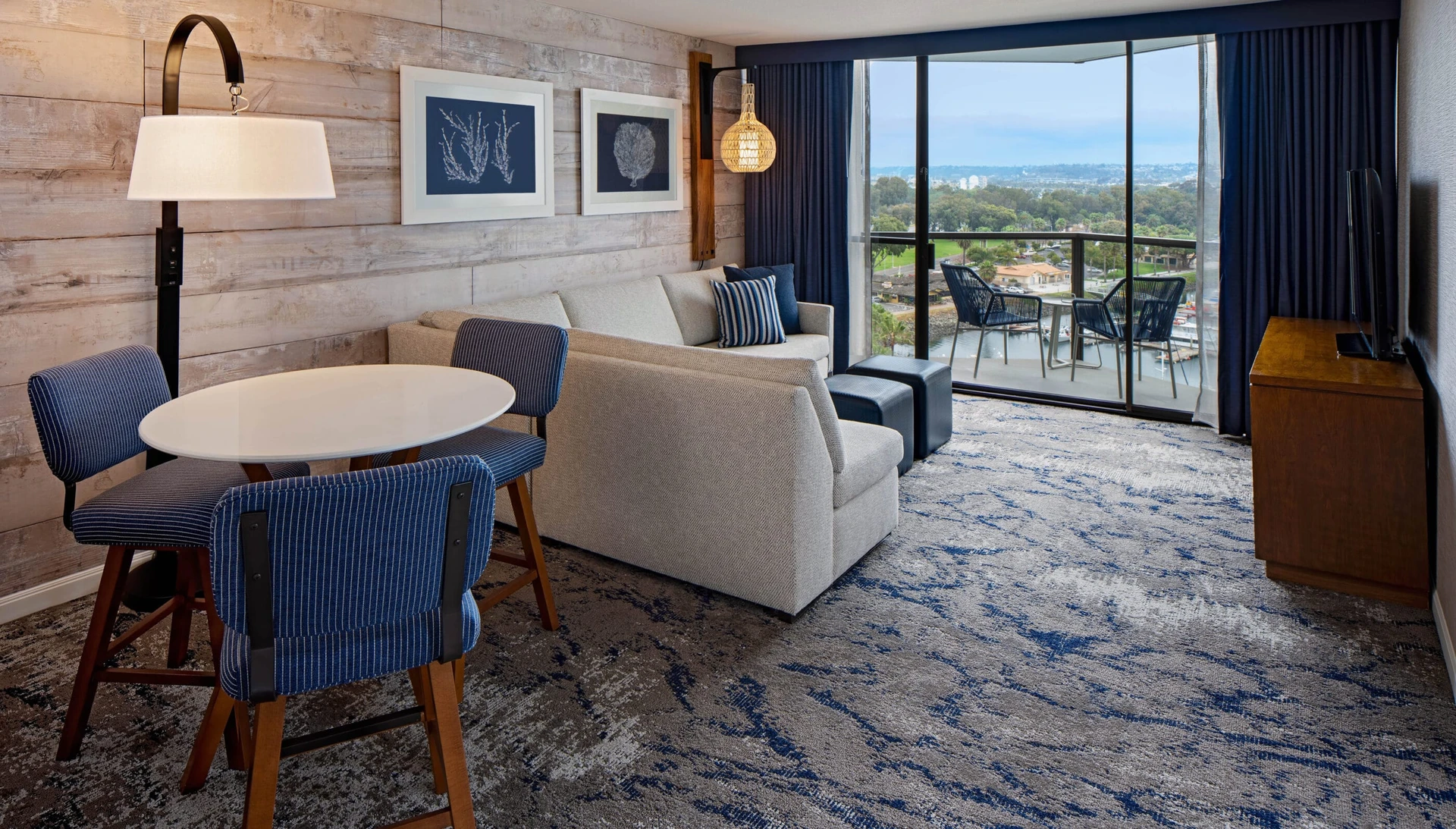 Corner Suite living room decorated in beige and blue looking over the balcony to the bay.