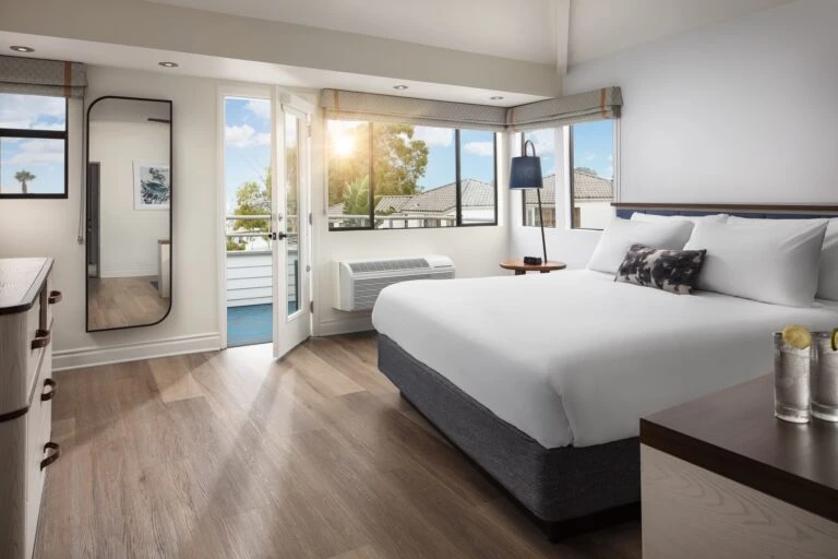 A king bed inside of an ocean view suite at Hotel Indigo Del Mar