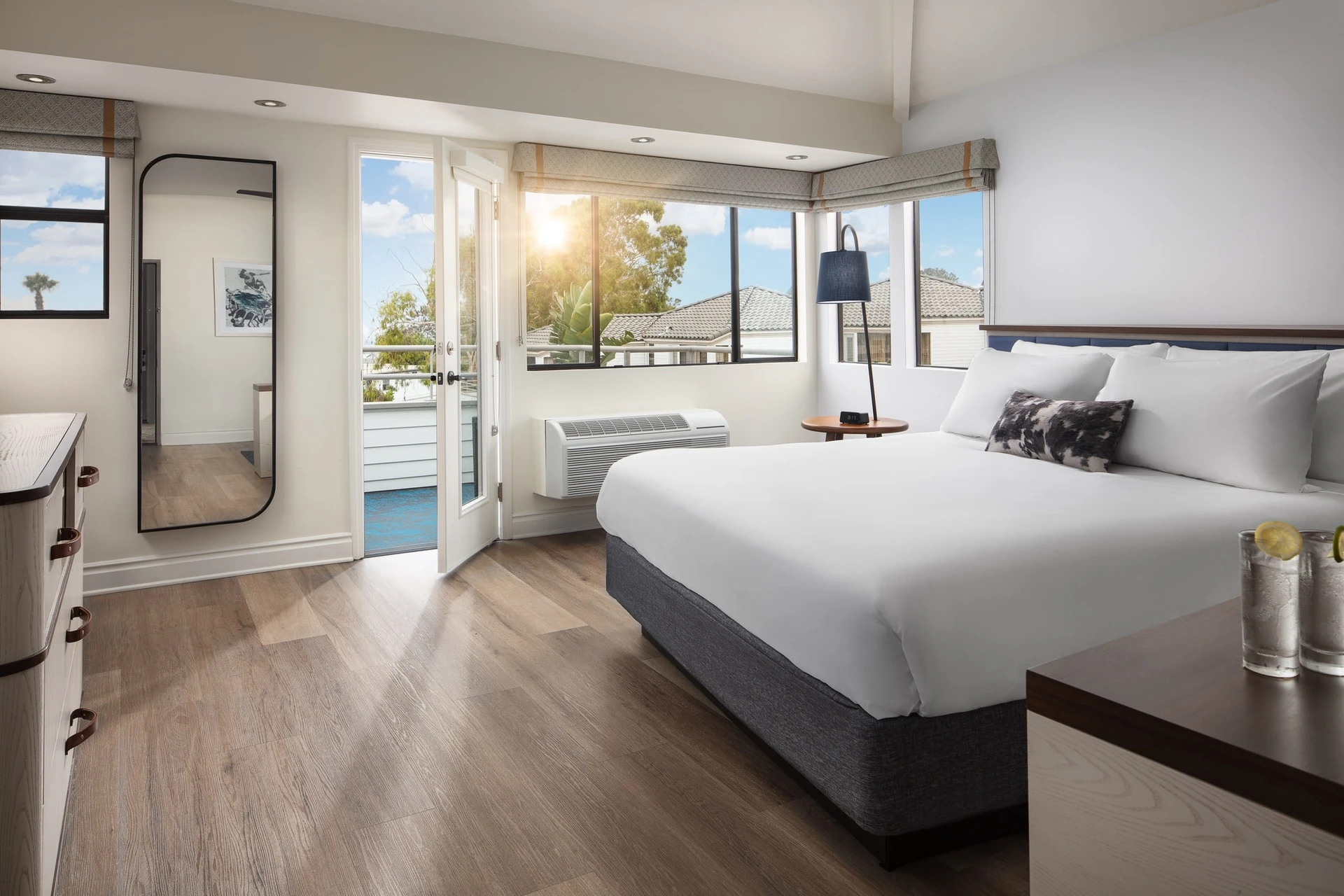 A king bed inside of an ocean view suite at Hotel Indigo Del Mar