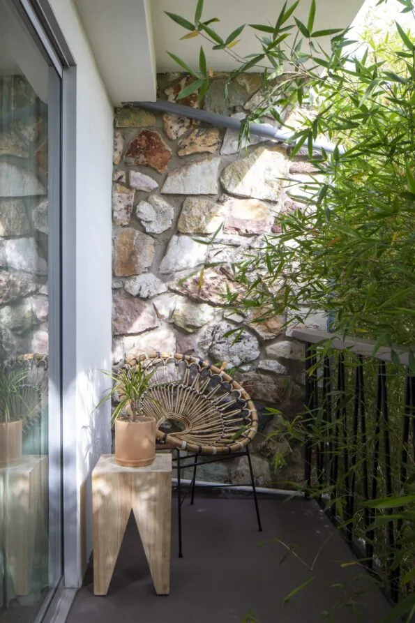 Seating and a wooden table on a balcony of a Grand Pearl room.