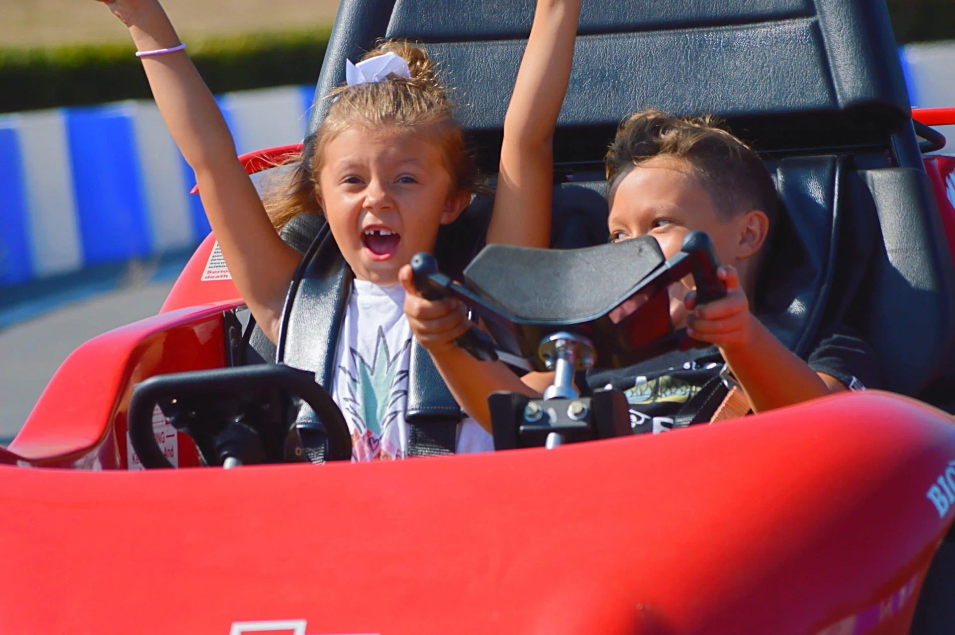 Two girls drive the Go Karts at Belmont Park San Diego