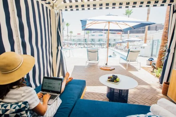 A guest works on a laptop from a cabana at the Main Pool.