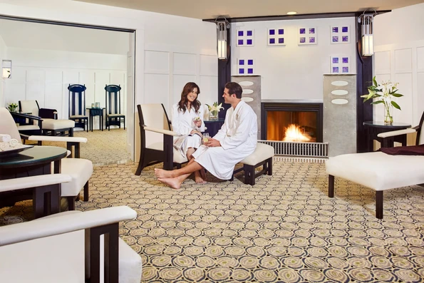 A couple in robes lounges in The Lodge at Torrey Pines spa waiting room.