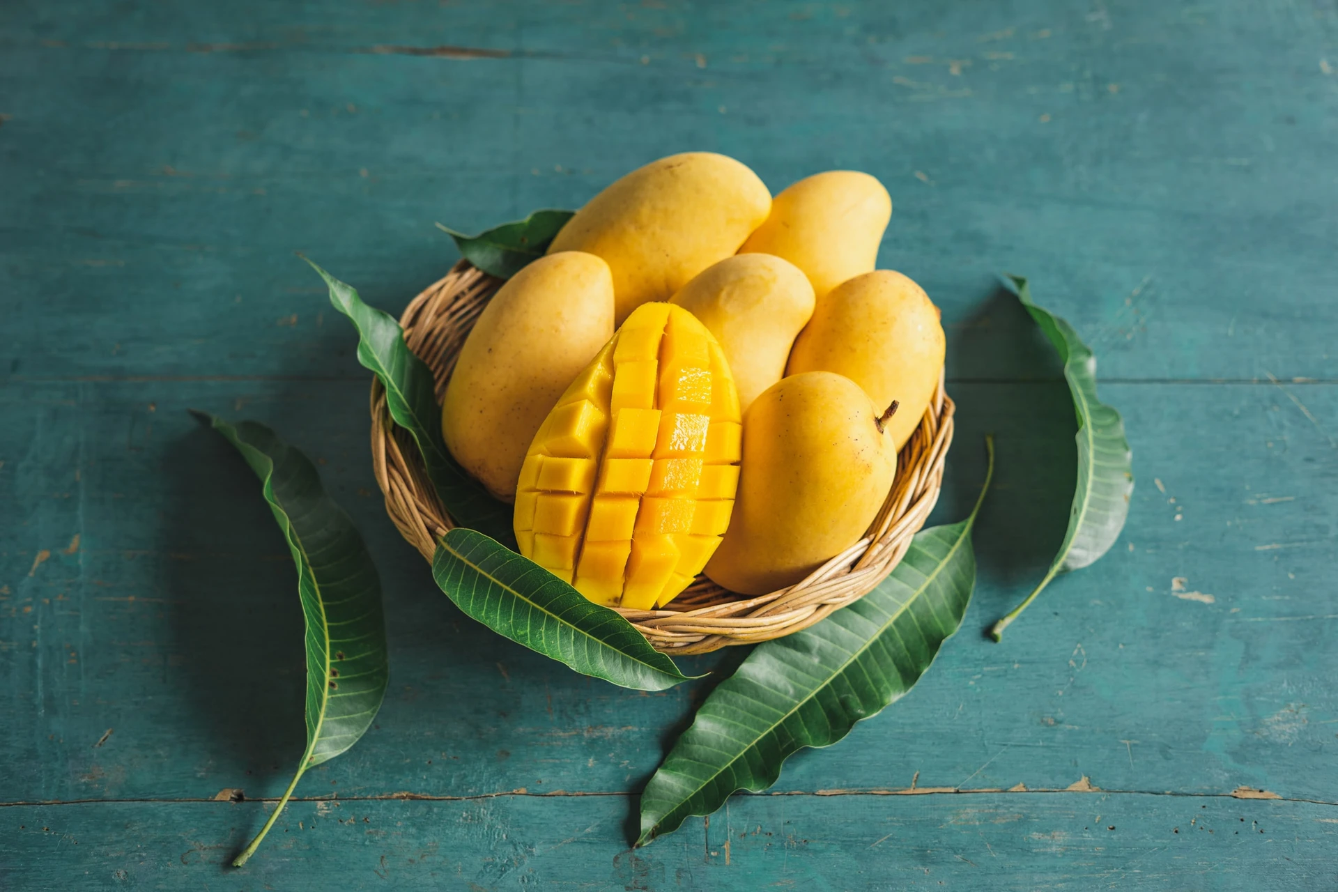 Mango in a basket on a green wood