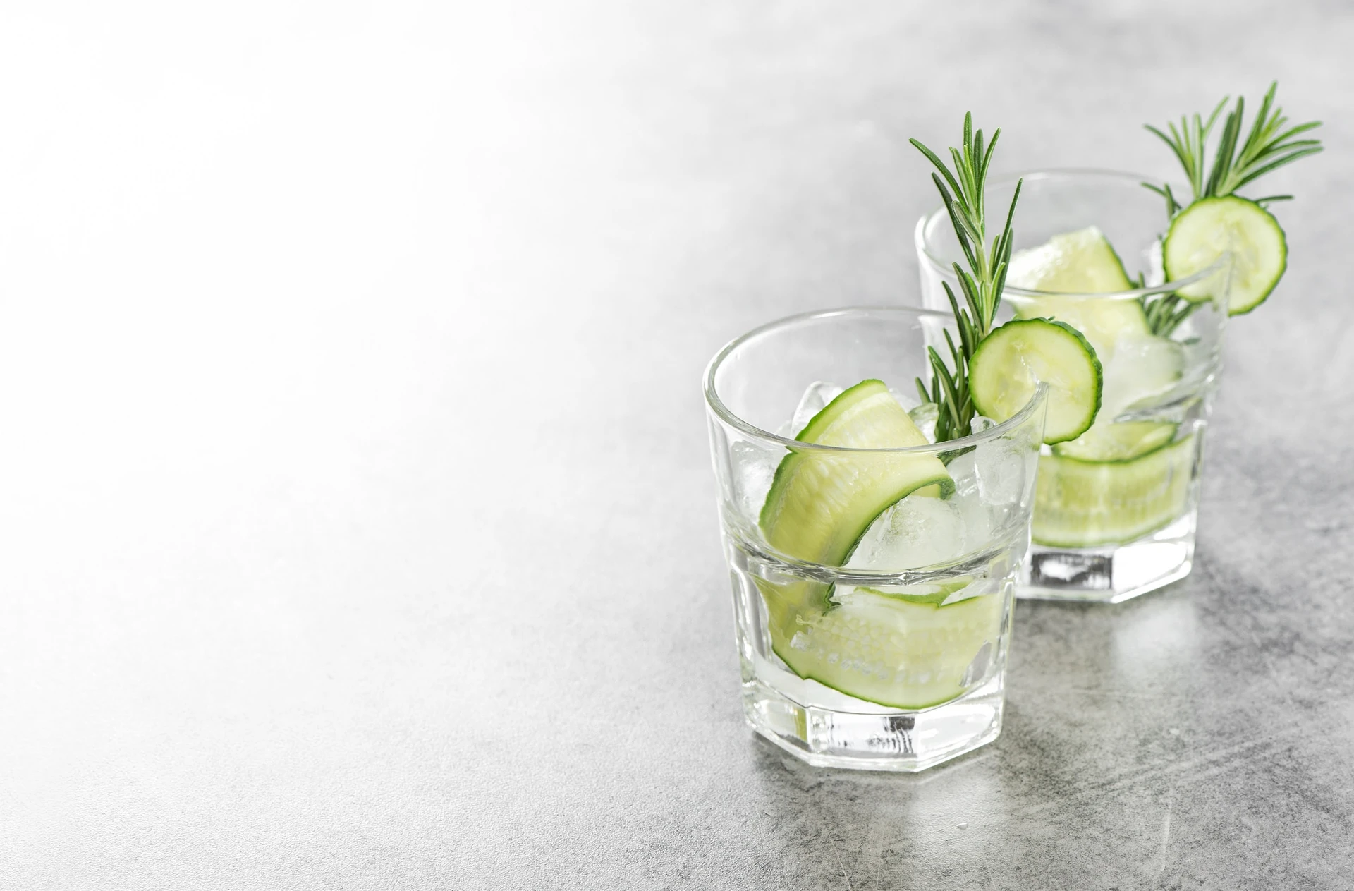 Fresh drink with cucumber, ice and rosemary herb