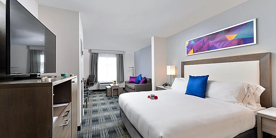 A modern king guest room interior at Holiday Inn Express Suites.