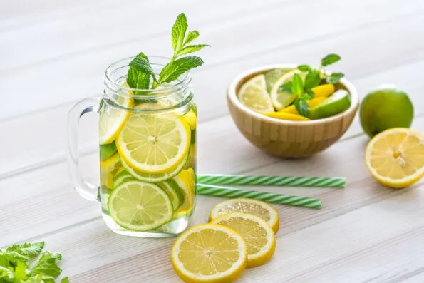 Lemon and lime infused water in a mason jar on a wooden table.