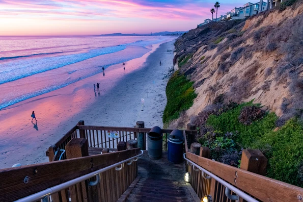 View of the stairs and bluffs at Grandview Beach in Encinitas at dusk.