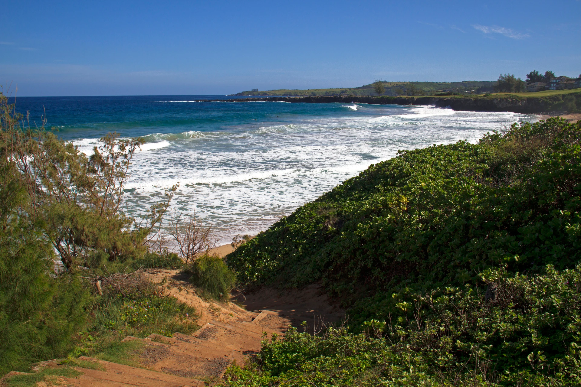 Stairs along Kapalua coastal trail going down to beach overlooking ocean.