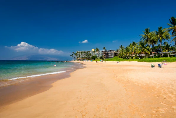 A few beachgoers enjoy the big gold sandy beach.