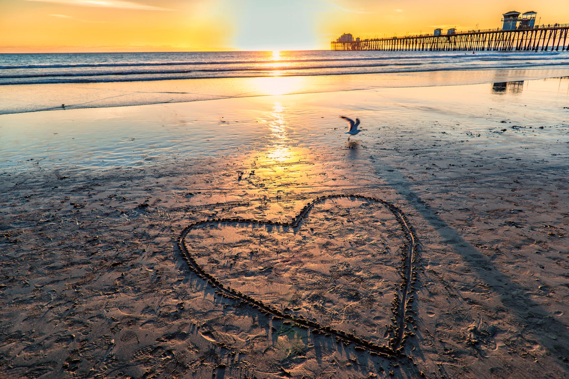 A heart drawn in the sand on Oceanside beach near the pierl