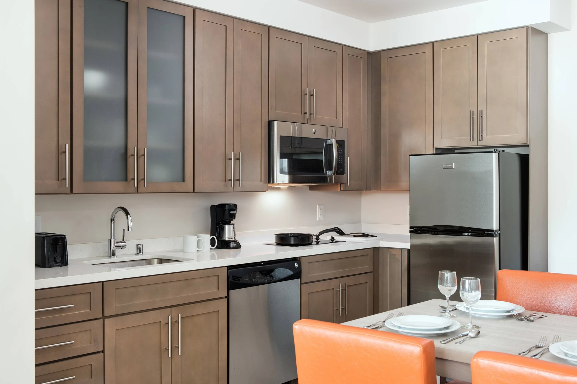 A large decent-sized kitchen with dining table inside one of the Residence Inn San Diego Downtown/Bayfront Suites.