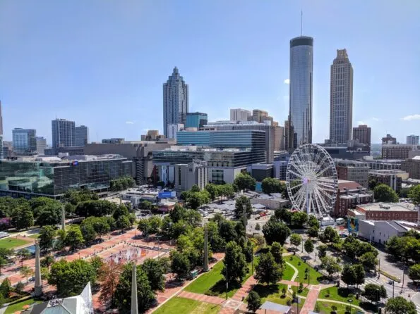Aerial view of Centennial Olympic Park and Ferris Wheel with skyscrapers in the background.