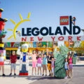 Happy guests stand in front of the LEGOLAND New York Entrance.