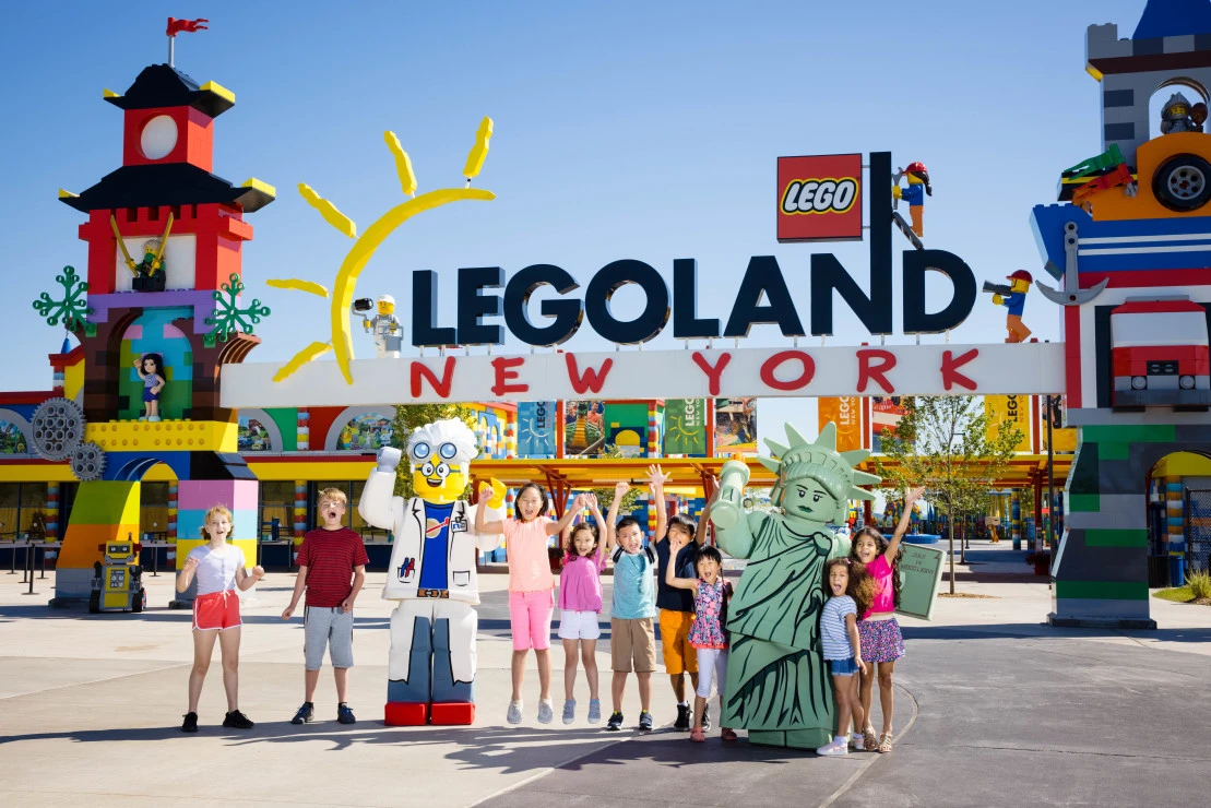 Happy guests stand in front of the LEGOLAND New York Entrance.