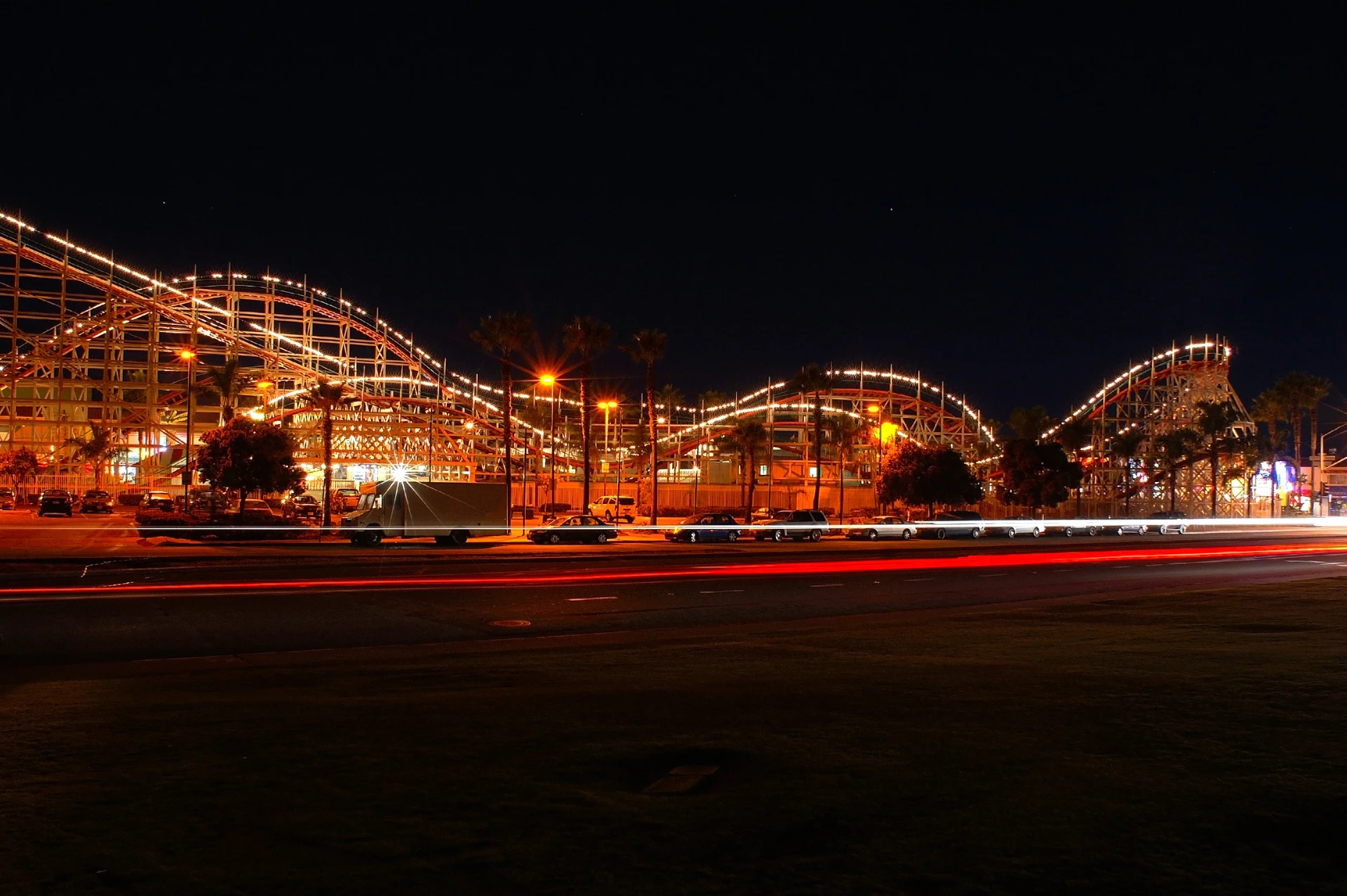 The Giant Dipper roller coaster at Belmont Park San Diego lit up with lights at night.